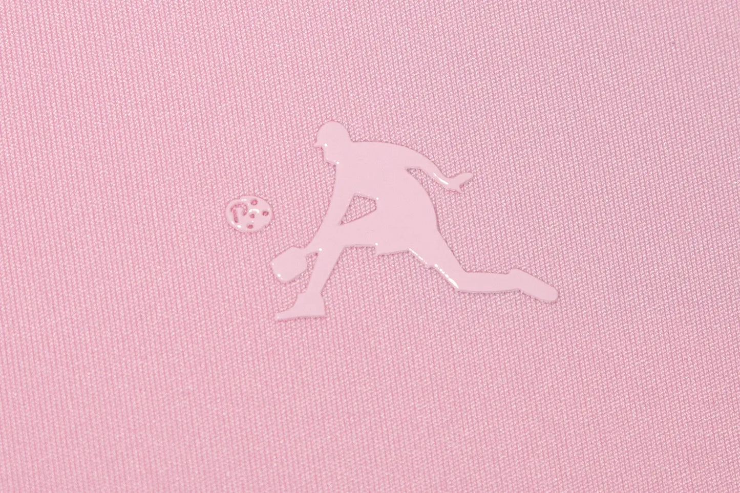 Silhouette of a pickleball player and ball on pink fabric