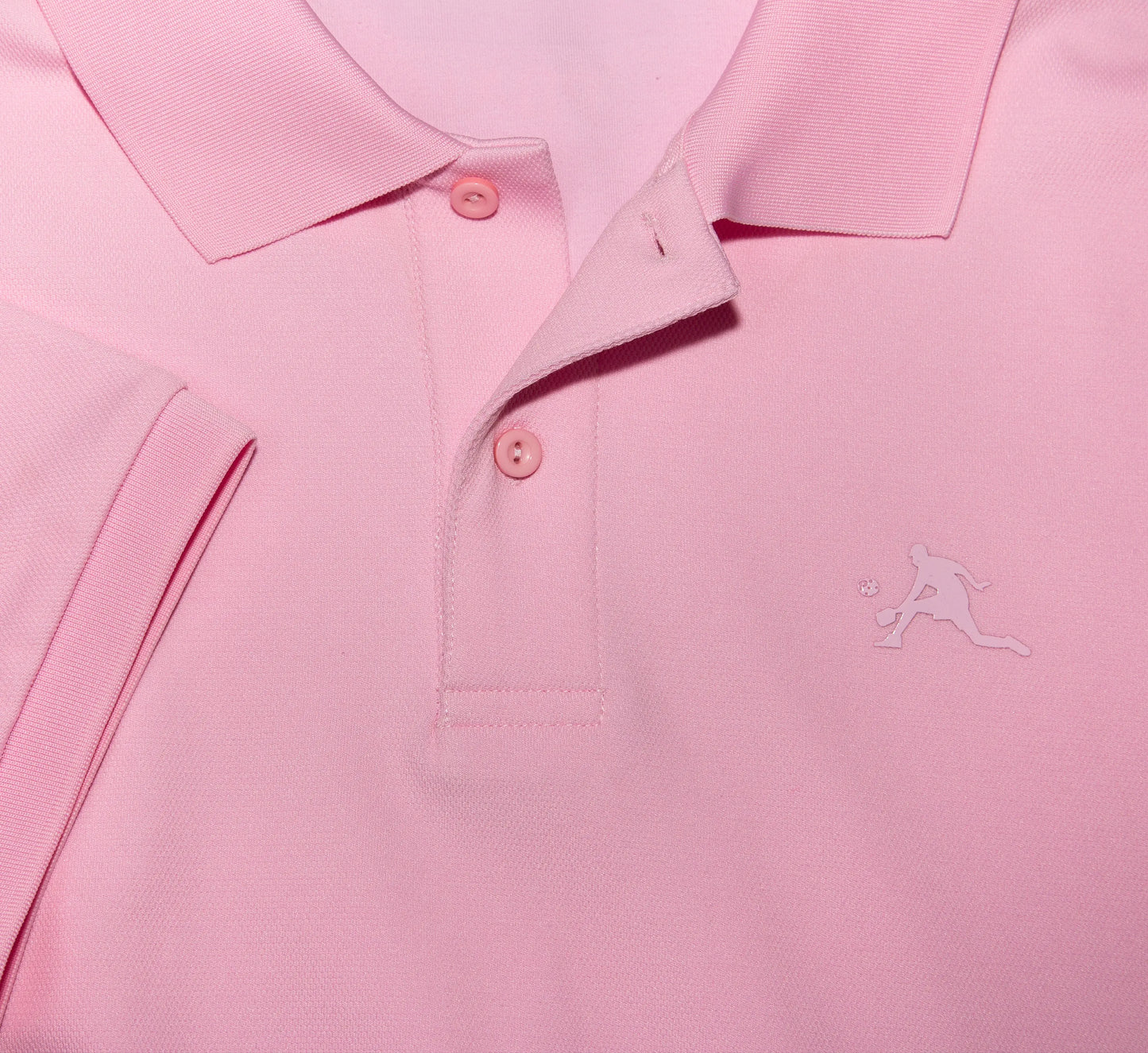 Gros plan d'un polo Rose avec un logo PBALL sur fond rose. Pink