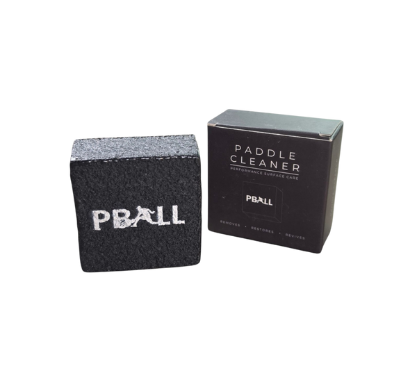 A black textured PBALLpaddle cleaner block next to its black retail box on a plain white background.