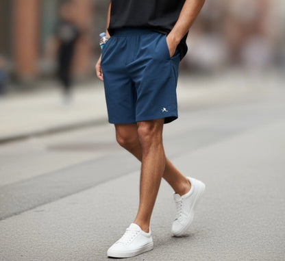 Person wearing blue shorts and white sneakers on a street.