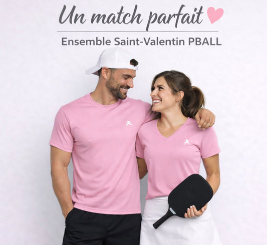 Couple wearing pink shirts with a pickleball paddle, standing against a light background.