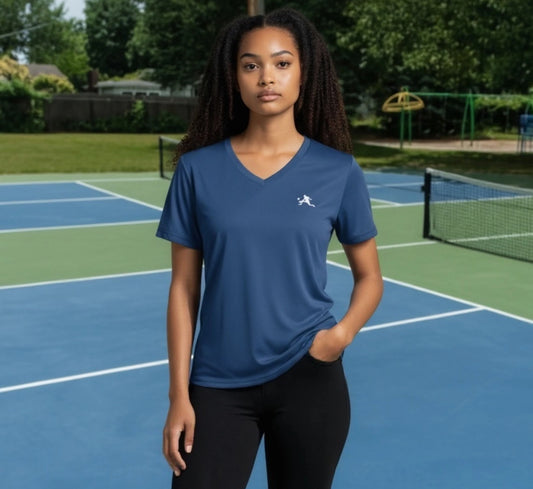 Woman wearing a blue athletic shirt with a logo on a pickleball court