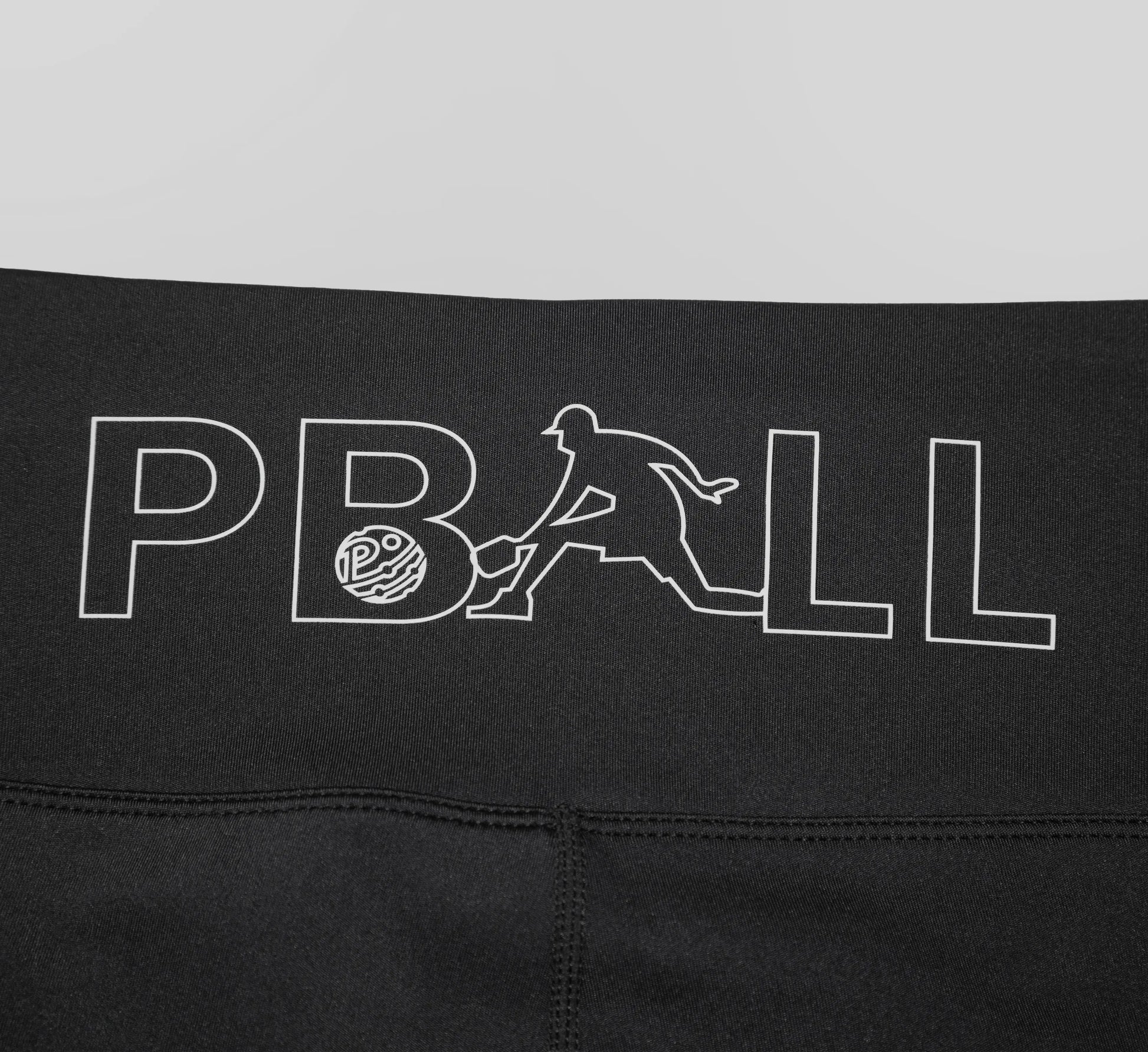 Black biker shorts with a white PBALL logo on a gray background