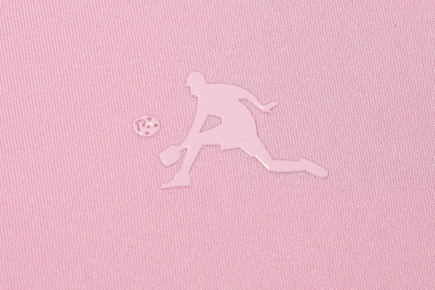 Silhouette of a pickleball player and ball on pink fabric