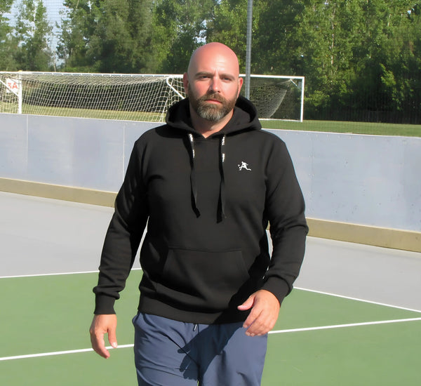 Man wearing a Black hoodie with a PBALL logo on a pickleball court Noir