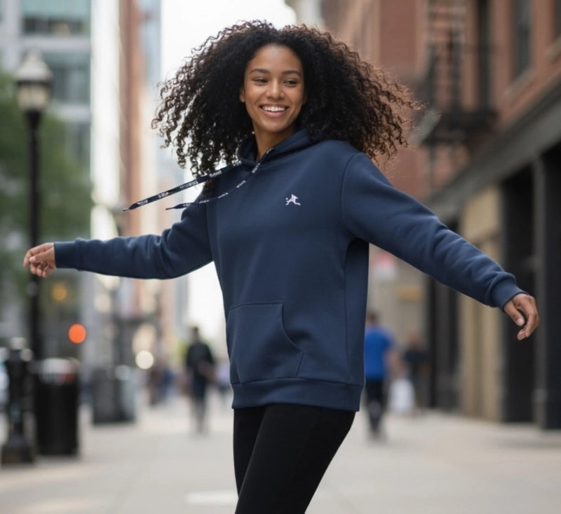 Woman wearing a blue hoodie with a logo on a city street