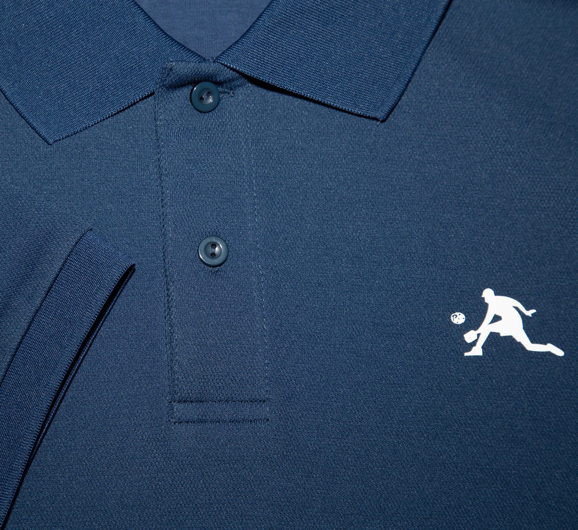 Close-up of a Blue polo shirt with a white PBALL logo on the chest Bleu