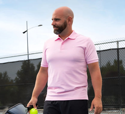 Man in a Pink polo shirt holding a pickleball ball on a pickleball court Rose