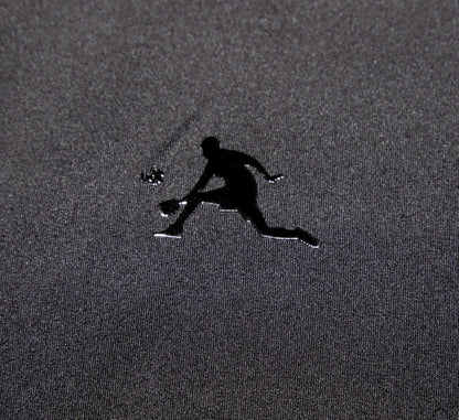 Black logo of a pickleball player on a textured gray surface Noir